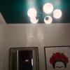 Techo pintado de verde y alumbrado en el centro del baño