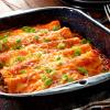 Enchiladas Gratinadas rellenas de Frijoles negros y queso de cabra con cama de salsa de vegetales horneados