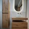 Baño reformado con mueble de madera suspendido y espejo LED ovalado en Reus - LUCMAR URBA