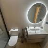 Baño con espejo LED de forma orgánica y mueble suspendido blanco en Reus - LUCMAR URBA