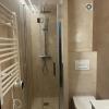 Ducha con mampara plegable y toallero eléctrico en un baño reformado en Salou - LUCMAR URBA