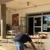 Operario trabajando en el acceso de un centro educativo de Reus con la zona acotada - LUCMAR URBA