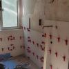 Alicatado de un baño con porcelánico blanco y niveladores en plena obra - LUCMAR URBA