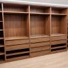 Vestidor a medida en madera con distribución funcional e iluminación.