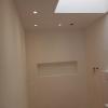 Reforma de baño con revestimiento en microcemento, iluminación cálida y diseño moderno tipo hotel.