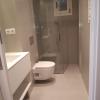 Reforma de baño con revestimiento en microcemento, iluminación cálida y diseño moderno tipo hotel.