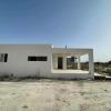 Vivienda con estructura metálica: vista lateral y porche durante la obra.