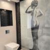 Panel decorativo de cristal con imagen artística femenina, integrado en el diseño exclusivo del baño.